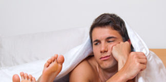 Man in bed next to feet