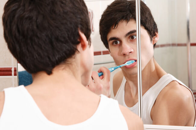 Young man brushing his teeth - deposit