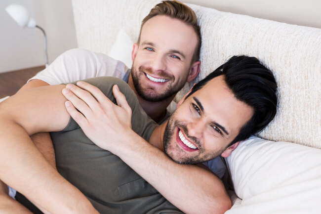 Happy gay couple in bed