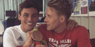 Tom Daley and Dustin Lance Black holding the medal