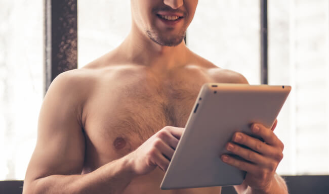 Shirtless man with tablet
